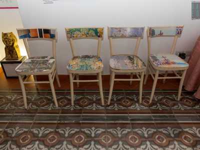 Qui anche le sedie esprimono inventiva: ne notiamo in particolare quattro sulla destra, decorate con la tecnica del decoupage
